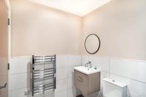 uma casa de banho branca com um WC e um espelho. em Modern & Stylish 2 Bed Apartment in Manchester em Manchester
