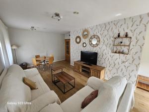 ein Wohnzimmer mit einem Sofa und einem TV in der Unterkunft BENIMAR 2 BEACH VIEW in Cala de Finestrat