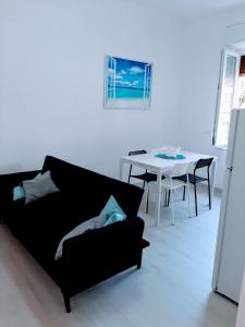 a living room with a black couch and a table at Casa Fuerte in Laigueglia