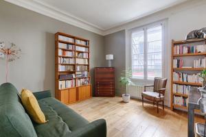a living room with a green couch and book shelves at Résidor - Haussmanian flat in the heart of Paris in Paris