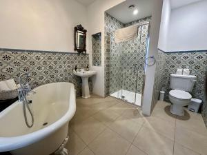 La salle de bains est pourvue d'une baignoire, de toilettes et d'une douche. dans l'établissement Claregalway Castle, à Claregalway