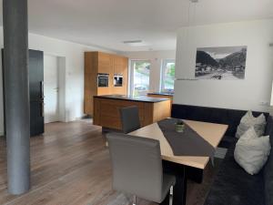 - une cuisine et une salle à manger avec une table et des chaises dans l'établissement Ferienwohnung BodnLois, à Matrei in Osttirol