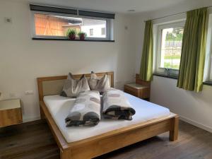 een slaapkamer met een bed met vier kussens erop bij Ferienwohnung BodnLois in Matrei in Osttirol