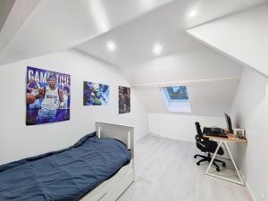 a bedroom with a bed and a desk with a computer at Maison Helena in Yerres