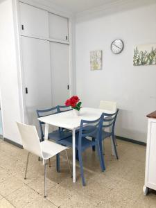 uma sala de jantar com uma mesa branca e cadeiras azuis em Nestor de la Torre I by Canary365 em Las Palmas de Gran Canaria