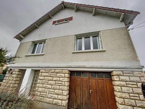 a house with a brown door and two windows at Maison Helena in Yerres