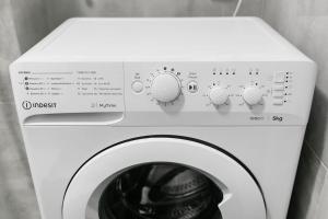 a white washing machine with buttons and dials on it at Mieszkanie blisko Zawiszy in Bydgoszcz