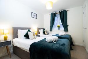 two beds in a bedroom with green and white at April Disc - Long Stay - Contractors in Swindon