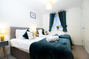 two beds in a bedroom with green and white at April Disc - Long Stay - Contractors in Swindon