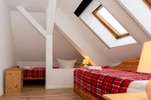 a attic bedroom with a bed and a skylight at Rosewood - Apartment by Comfort Housing in Falkensee