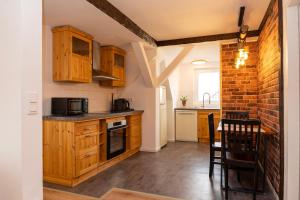 una cocina con armarios de madera y una pared de ladrillo en Rosewood - Apartment by Comfort Housing en Falkensee