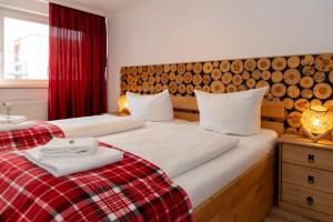 two twin beds in a room with a red curtain at REDWOOD by Tendo Stay - Comfort Housing in Falkensee