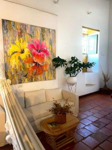 uma sala de estar com um sofá e uma pintura na parede em Hotel Boutique Casa de Los Santos Reyes Valledupar em Valledupar