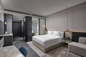 ein Hotelzimmer mit einem Bett und einem Stuhl in der Unterkunft Crowne Plaza Ezhou, an IHG Hotel in Ezhou