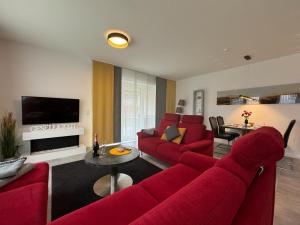 ein Wohnzimmer mit roten Möbeln und einem roten Sofa in der Unterkunft Strandloft-Frieshörn Nordsee Park Dangast in Dangast