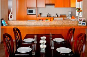 a dining room table with chairs and a kitchen at Marriott Executive Apartments Dubai Creek in Dubai