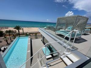 a balcony with a view of a swimming pool and the beach at The Hype Beachhouse in Playa de Palma