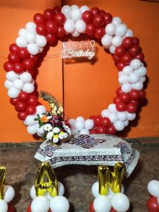 a red and white balloon arch with a happy birthday sign at Kashi dham Homestay ( close to Kashi Vishwanath temple and Ghats) in Varanasi