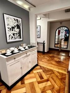 a kitchen with white cabinets and a wooden floor at Hotel Boutique Tremo Bellavista Suite in Santiago