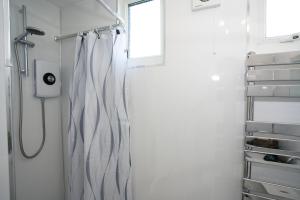 a shower curtain in a bathroom with a window at Sea Lavender Holiday Chalet, close to sandy beach in Heacham +14 photos