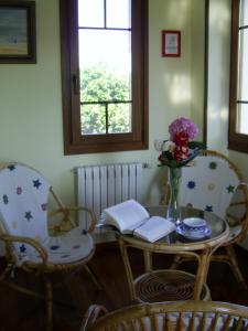 una mesa y sillas con un jarrón de flores. en Casa Fonso, en Villapedre