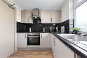a kitchen with white cabinets and a sink at Serviced Ensuite Modern Studio - Sleeps 2 - Near Wembley Stadium - Good Transport Link to Central London - Harrow HA3 in Hatch End