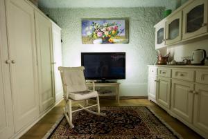 a living room with a chair and a television at La Contrada B&B in Casnate con Bernate
