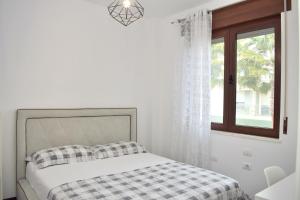 ein weißes Schlafzimmer mit einem Bett und einem Fenster in der Unterkunft Lalzit Bay Dream Villa - Happy Rentals in Lalzit Bay