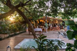 a hot tub in a garden with a restaurant at Shongwe Oasis in Victoria Falls