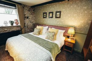 a bedroom with a large bed and a window at The Ashford Arms in Bakewell