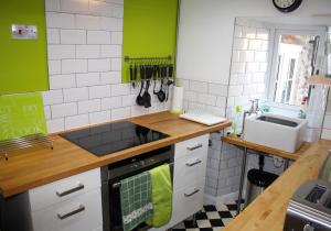 a kitchen with green and white tiles and a sink at Dinmore in Richmond