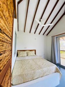 a bedroom with a bed and a large window at Cabaña cerca al Mar con Pisicina y AC en Tolú in Tolú