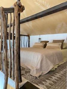 um quarto com uma cama de madeira num quarto em Le Mas des Perrines Maison d’Hôtes em Pernes-les-Fontaines