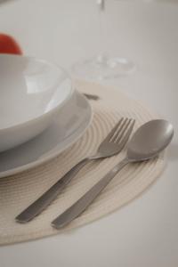 two silverware sitting on a napkin next to a plate at Residencial Neade Suites in Sanlúcar de Guadiana