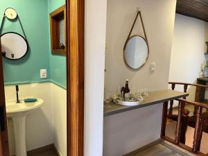 a bathroom with a sink and a mirror at Excelente e bem no centro - @stayhousetemporada in Canela +25 photos