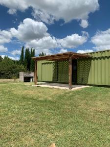 a large green building with a grass field at Casa Container Chacra 202 in Tandil