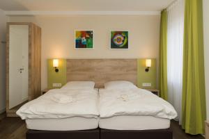 um quarto com duas camas brancas em Roca Restaurant und Hotel em Bommersheim