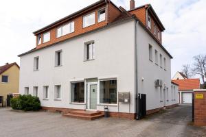 a white building with a brown roof at Sunny Side - Apartment by Comfort Housing in Falkensee