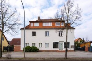 una gran casa blanca con techo rojo en Sunny Side - Apartment by Comfort Housing, en Falkensee