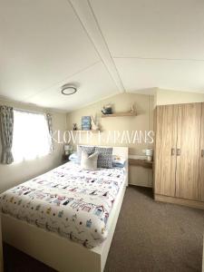 1 dormitorio con 1 cama con un cartel que lee karaways más bajos en Seton Sands Holiday Park Klover Karavans, en Port Seton
