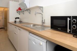 a kitchen with a sink and a microwave at FRAME by Tendo Stay - Comfort Housing in Falkensee +8 photos