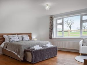 a white bedroom with a bed and a window at The Crofts in Winsford