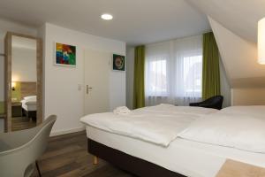 um quarto com uma grande cama branca e uma janela em Roca Restaurant und Hotel em Bommersheim