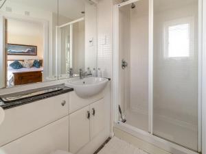 uma casa de banho branca com um lavatório e um chuveiro em Beachview em Llanelli