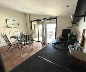 Una cocina y una sala de estar con mesa y sillas. en Commanderie Vue Panoramique 2 chambres, en Le Poët-Laval