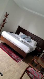 a bed with a wooden headboard in a bedroom at Twiga Whitehouse Villas in Nakuru