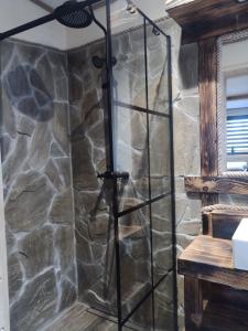 ducha en una habitación con pared de piedra en Trzy Kopce 