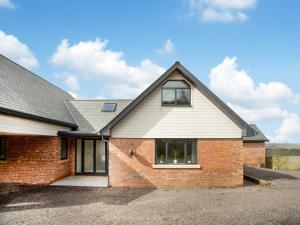 a brick house with a gambrel roof at Deer View in Ottery Saint Mary