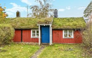 a red house with a grass roof with a blue door at 1 Bedroom Gorgeous Home In Kpingsvik in Köpingsvik