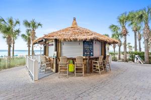 a hut with chairs and a table in front of the beach at Calypso Beach Resort Towers in Panama City Beach